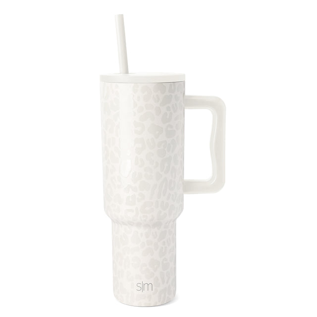 White and cream leopard print insulated tumbler with matching lid, white straw, and curved handle on white background. Simple Modern SM logo visible on front. White and cream leopard print insulated tumbler with matching lid, white straw, and curved handle on white background. Simple Modern SM logo visible on front.