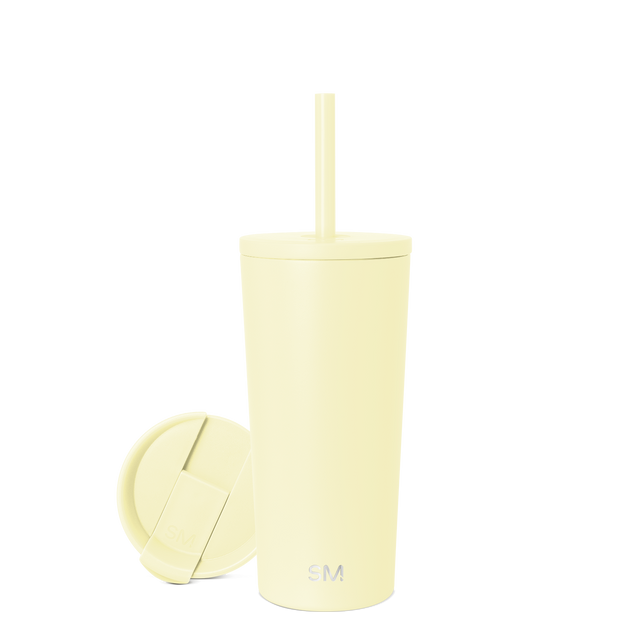 Pale yellow reusable cup with matching lid and straw on white background Pale yellow reusable cup with matching lid and straw on white background