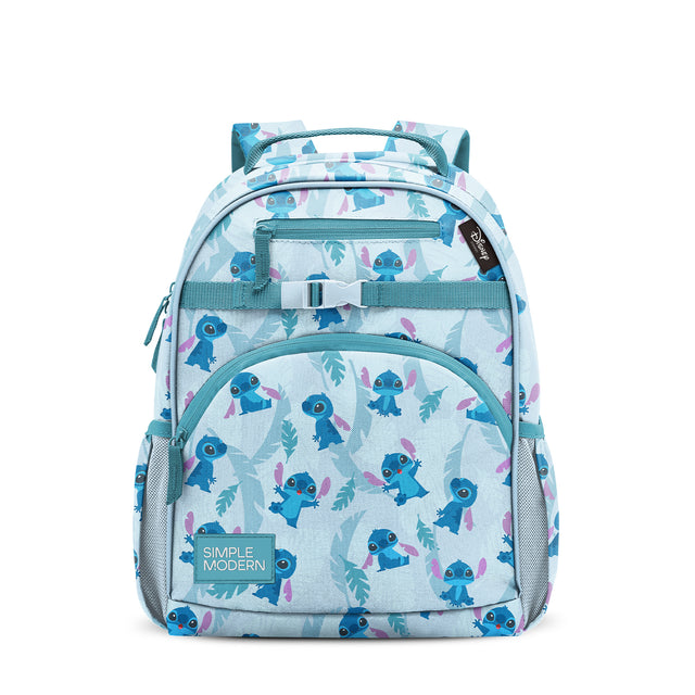 Light blue children's backpack with teal handles and straps, featuring an all-over pattern of blue cartoon alien characters with pink wings and teal leaves. Front zippered pocket, side mesh panels, and Simple Modern brand Light blue children's backpack with teal handles and straps, featuring an all-over pattern of blue cartoon alien characters with pink wings and teal leaves. Front zippered pocket, side mesh panels, and Simple Modern brand