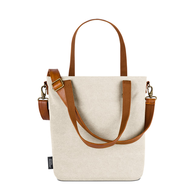 Cream canvas tote bag with cognac brown and tan leather accents and handles Cream canvas tote bag with cognac brown and tan leather accents and handles