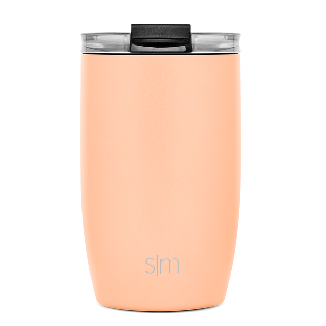 Soft peach tumbler with clear transparent band, black lid and handle on white background Soft peach tumbler with clear transparent band, black lid and handle on white background