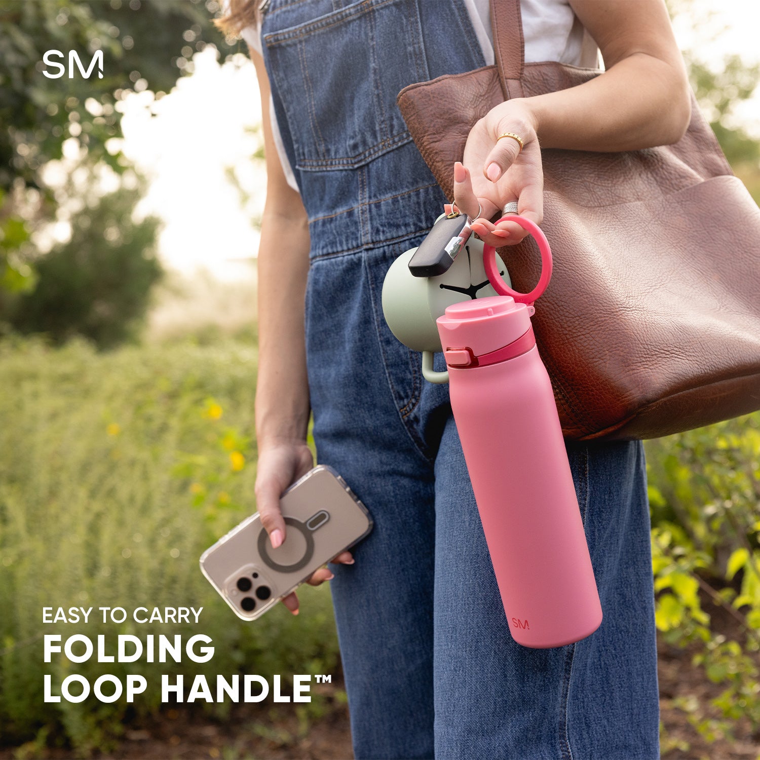 Woman holding Mesa Loop by the loop handle with text that calls out the easy to carry folding loop handle