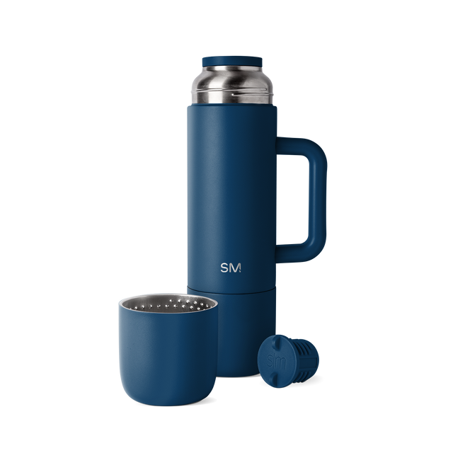 Navy blue romertopf clay baker with stainless steel silver handles and lid knob, displayed against a white background. Navy blue romertopf clay baker with stainless steel silver handles and lid knob, displayed against a white background.