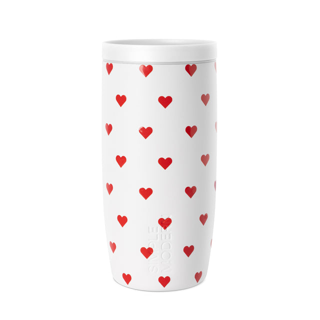 White insulated tumbler with secure lid featuring a repeating red heart grid pattern, centered on white background. White insulated tumbler with secure lid featuring a repeating red heart grid pattern, centered on white background.