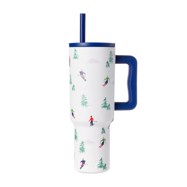 White insulated tumbler with navy blue lid, handle, and straw, featuring forest green evergreen tree design accents White insulated tumbler with navy blue lid, handle, and straw, featuring forest green evergreen tree design accents