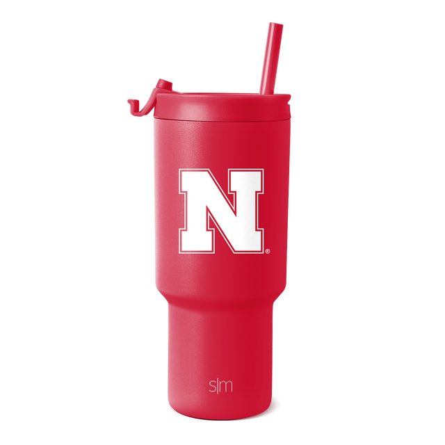Crimson red tumbler with matching red straw on white background Crimson red tumbler with matching red straw on white background