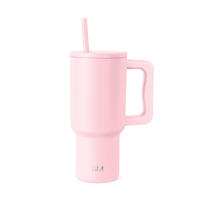 Pale pink insulated tumbler with handle on white background Pale pink insulated tumbler with handle on white background