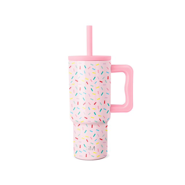 Tall pink insulated tumbler with handle and confetti sprinkle pattern design on white background Tall pink insulated tumbler with handle and confetti sprinkle pattern design on white background