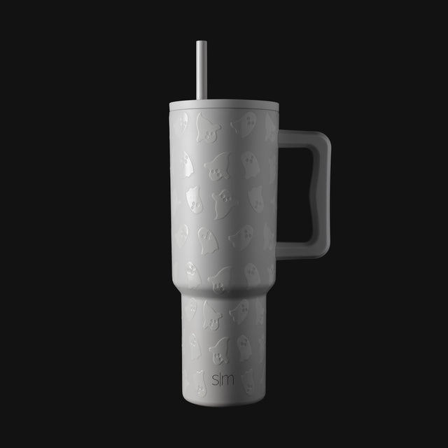 White insulated tumbler with dark charcoal handle and lid, displayed against a dark background. White insulated tumbler with dark charcoal handle and lid, displayed against a dark background.