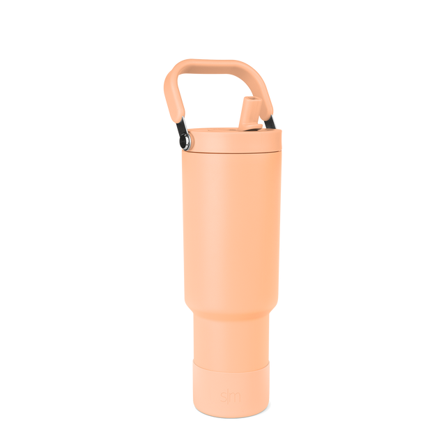 Peach-colored water bottle with black handle hardware and accents Peach-colored water bottle with black handle hardware and accents
