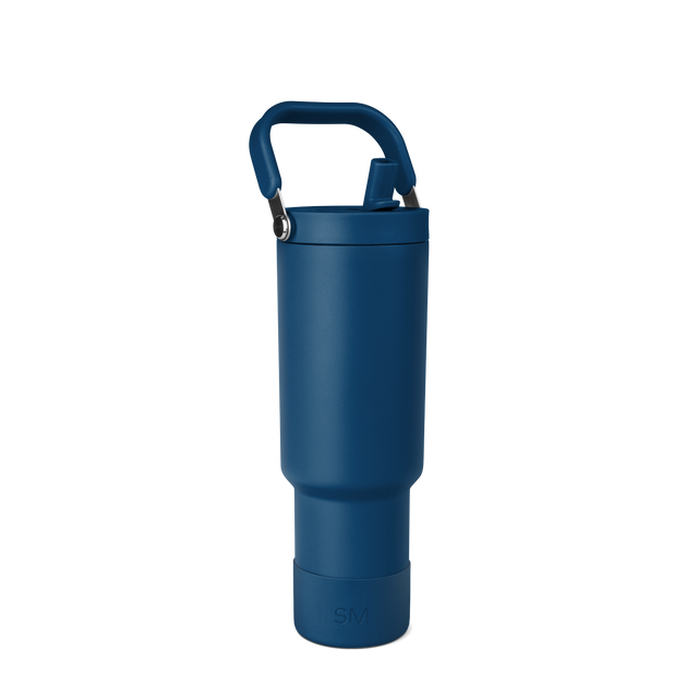 Deep navy blue tote bag with gunmetal gray metal hardware and handles against a white background. Deep navy blue tote bag with gunmetal gray metal hardware and handles against a white background.