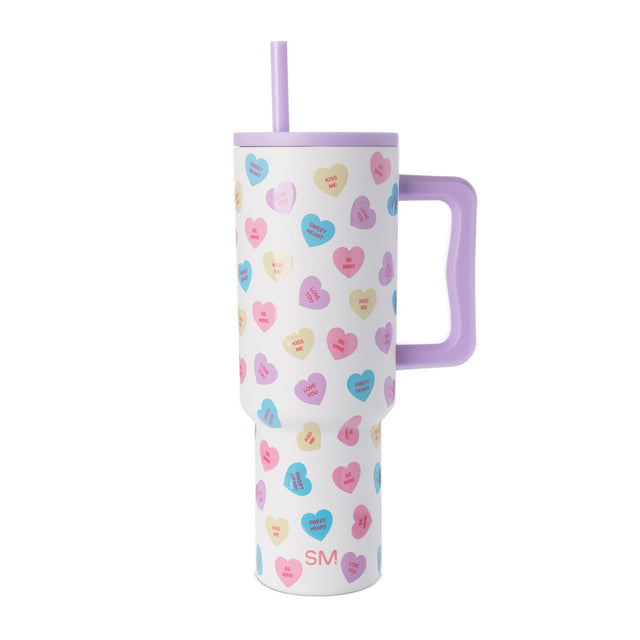 White tumbler with lavender purple lid, handle, and straw; pastel pink and sky blue accents visible on design White tumbler with lavender purple lid, handle, and straw; pastel pink and sky blue accents visible on design