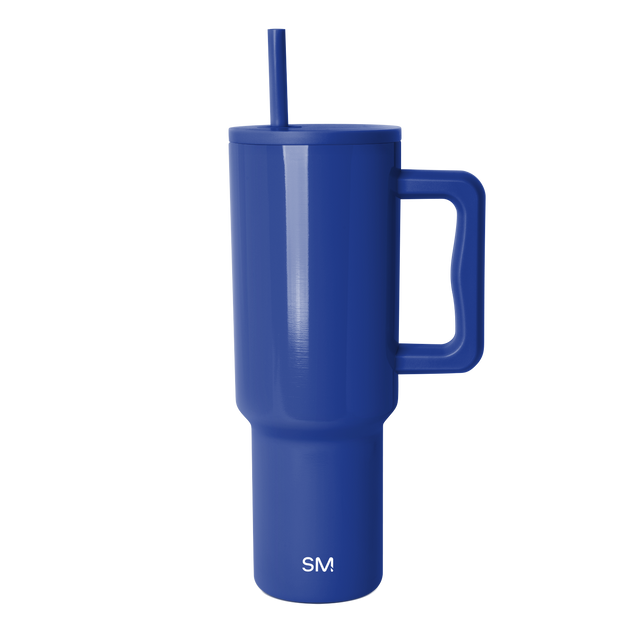 Tall cobalt blue insulated tumbler with cylindrical body and tapered base against white background Tall cobalt blue insulated tumbler with cylindrical body and tapered base against white background