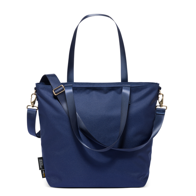 Harper Tote in deep navy blue Cordura fabric with gold-toned hardware, featuring dual handles and detachable crossbody strap, displayed on white background. Harper Tote in deep navy blue Cordura fabric with gold-toned hardware, featuring dual handles and detachable crossbody strap, displayed on white background.