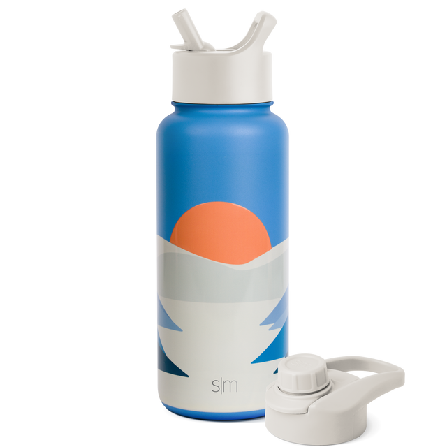 Insulated water bottle with cobalt blue exterior and vibrant coral-orange sun graphic in the center