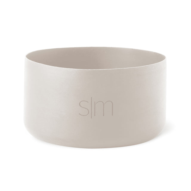 Pale cream-colored cylindrical vessel with soft gray interior walls against a neutral background.