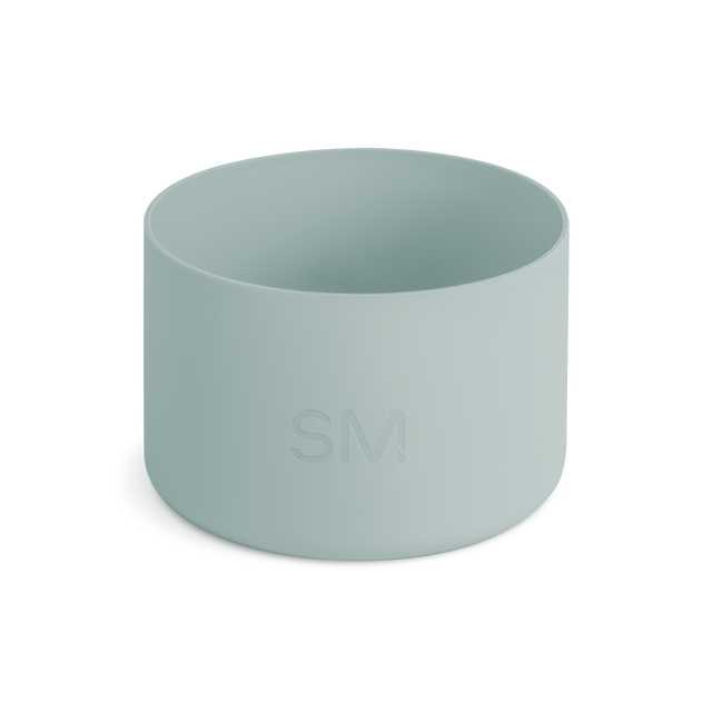 Soft sage green hiking boot with lace-up closure and visible tread sole, photographed against a neutral light gray background.