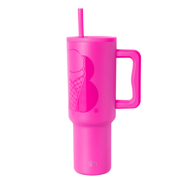 Hot pink insulated tumbler with handle and reusable straw on white background. Tapered design widens at top, narrows at base.