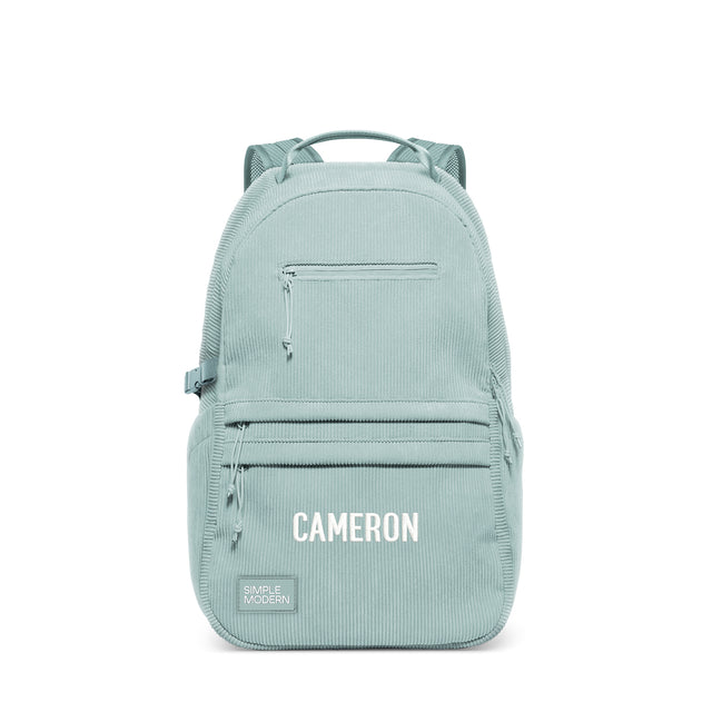 Sage green structured backpack with multiple zippered pockets, padded mesh shoulder straps, and top carry handle. Features 