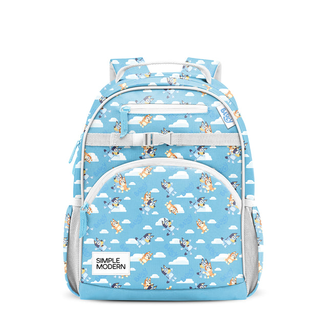 Sky blue Simple Modern children's backpack with cartoon blue heeler puppies and clouds pattern, padded shoulder straps, front pocket, side mesh pockets, and top handle. Studio product shot on white background.