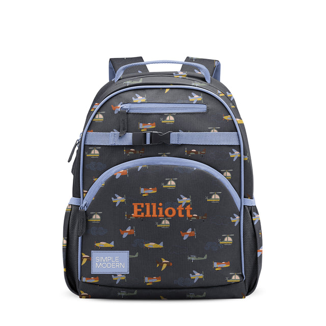 Children's backpack with charcoal gray base, periwinkle blue straps and pockets, featuring transportation-themed print with airplanes and sailboats. 