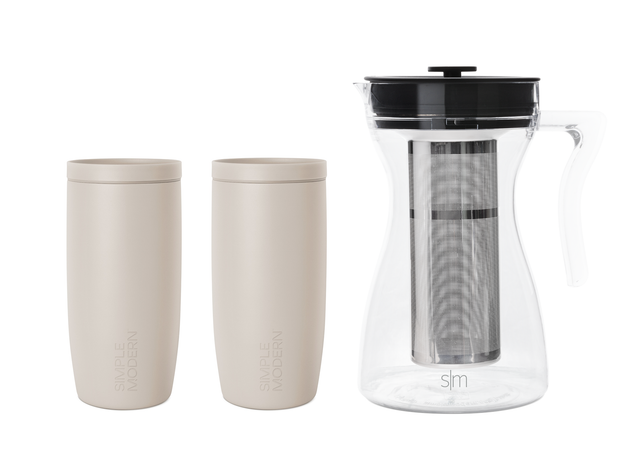 Two beige ceramic cylindrical vessels next to a clear glass pitcher on white background