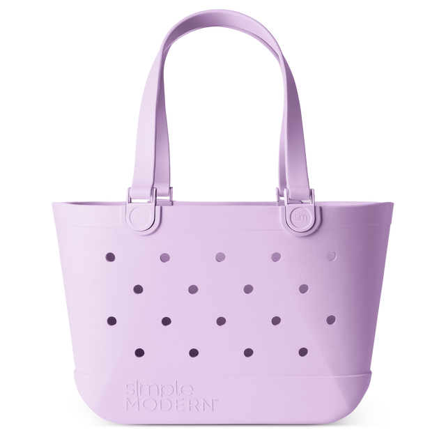 Lavender purple tote bag with dual padded handles, perforated circular hole pattern on front, metal SM logo hardware, and simple MODERN branding on white background.