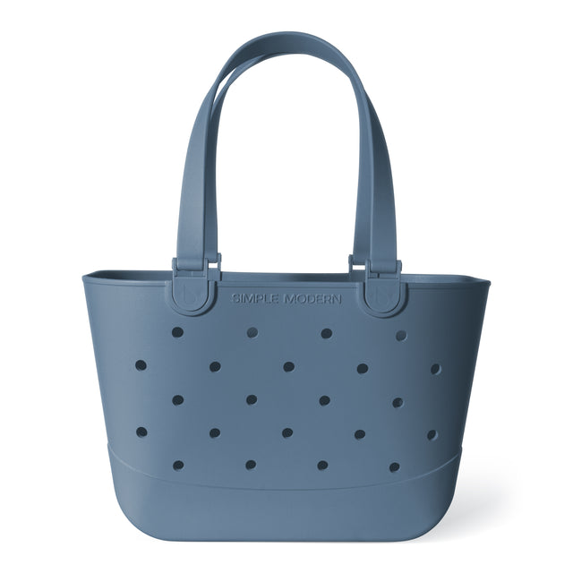 Muted slate blue tote bag with black perforations throughout the design