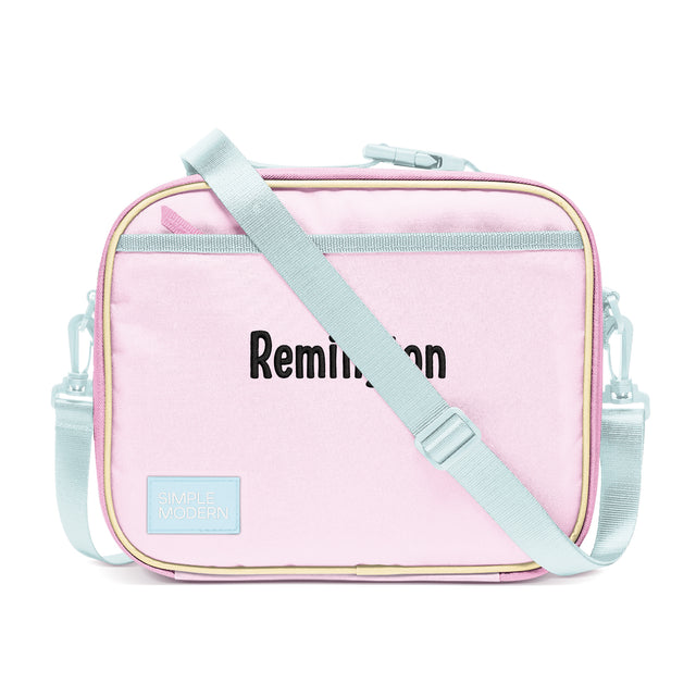 Pale pink rectangular lunch bag with sage green shoulder strap and handles, cream piping trim, and 