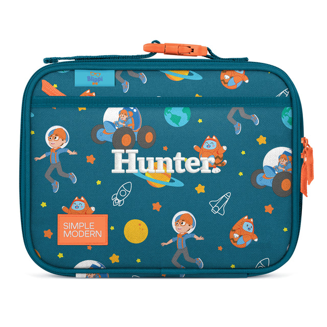 Teal insulated lunch box with space-themed design featuring cartoon astronauts, rockets, and planets. Orange carry handle and zipper pulls. Blippi brand character 