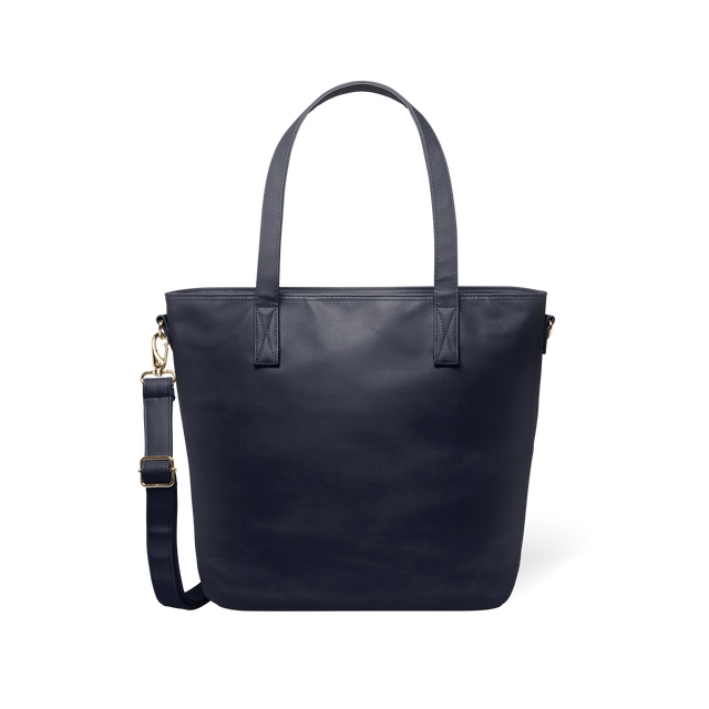 Deep navy modern tote bag with brass-toned metal hardware and handles, displayed flat against a white background