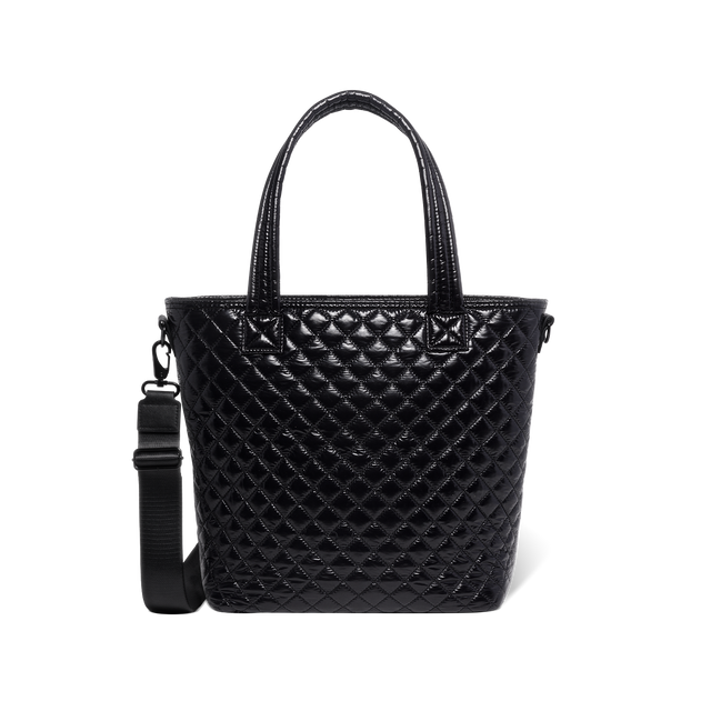 Black quilted handbag with light reflections on white background