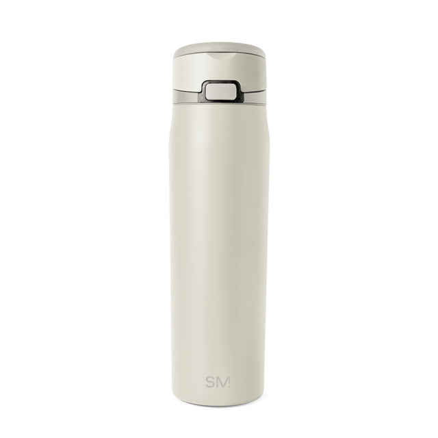 Cream-colored bottle with dark gray accents on neutral beige background