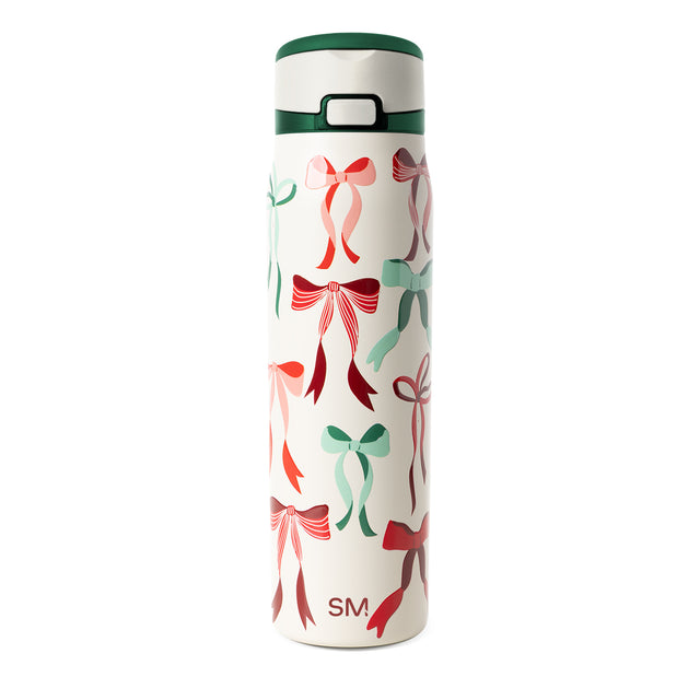 Cream-colored tumbler with forest green lid and band, decorated with coral pink bow motifs