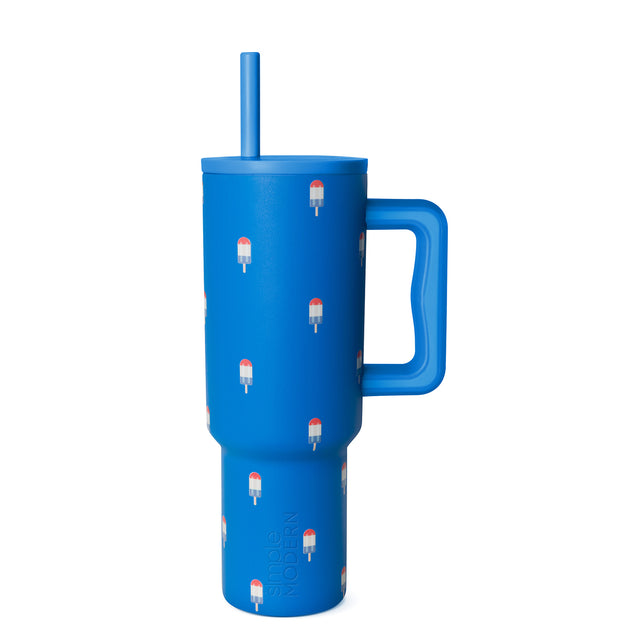 Bright cobalt blue insulated tumbler with handle and straw on white background
