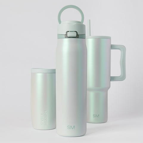 Soft sage green mug with pearlescent shimmer and iridescent finish, white background, minimalist product shot for spring collection drinkware.