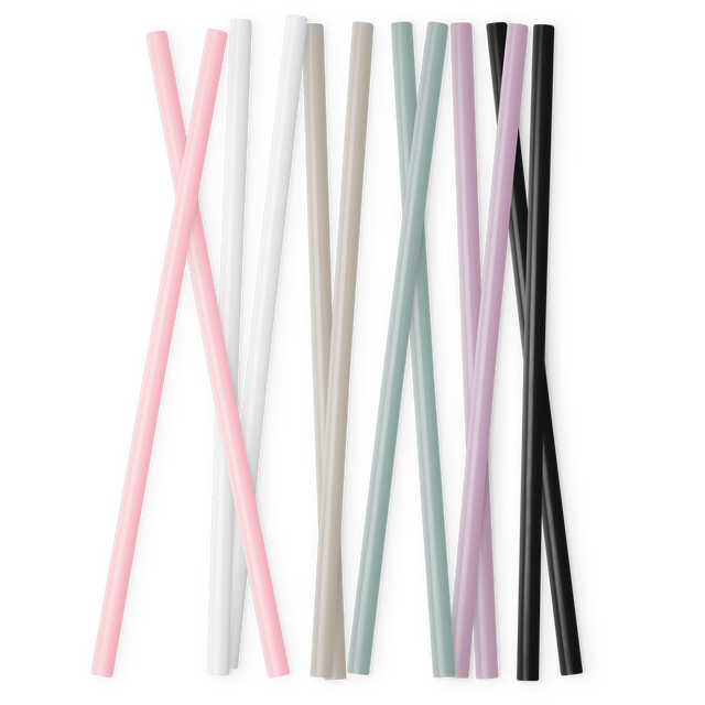Set of reusable straws in soft pink, white, taupe, and beige colors arranged neatly in an organized display against a clean background.