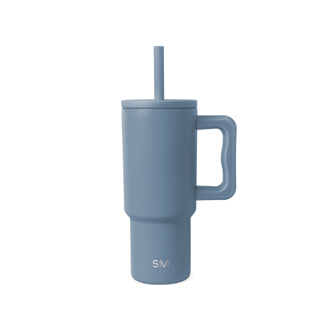 Slate blue dusty tumbler with white interior against neutral off-white background