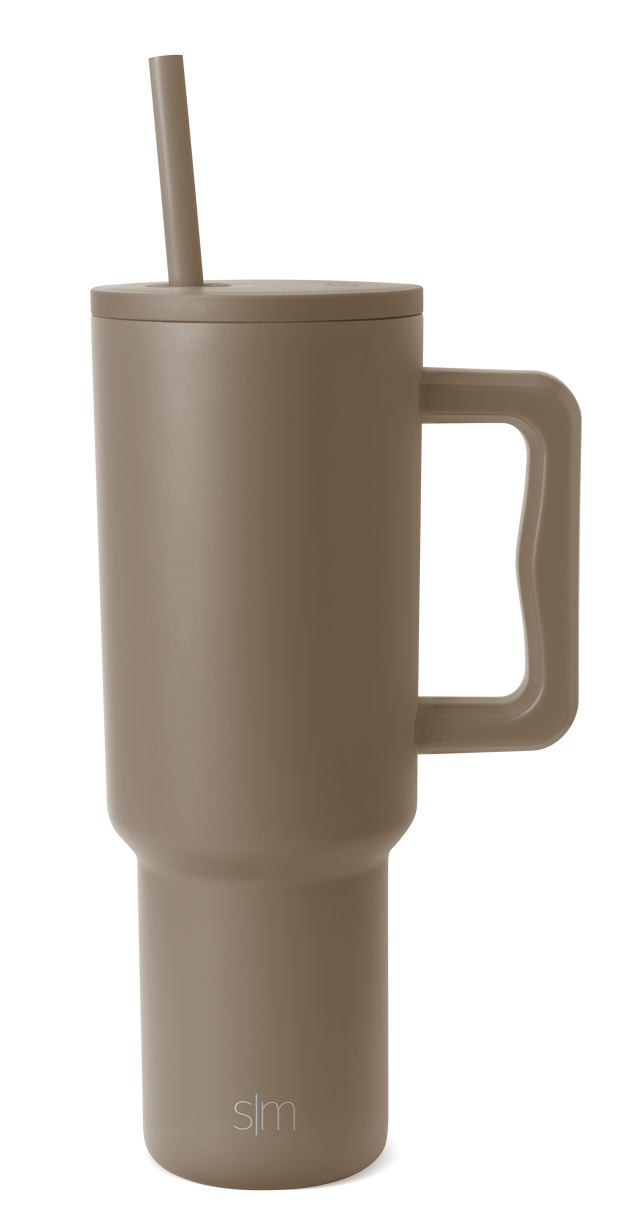 Taupe ceramic travel mug with white background, featuring a cylindrical shape with a secure lid and handle, designed for hot beverages