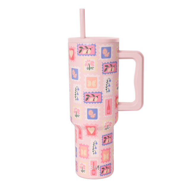 Soft pink tumbler with vibrant coral red, purple blue, orange, and cream accent colors layered across the design