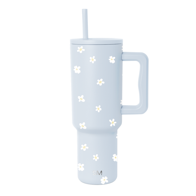 Pale blue tumbler with white daisy flower motifs and pale yellow accents on clean white background