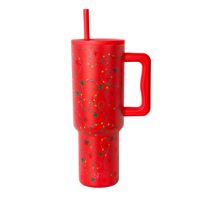 Bright red tumbler with festive holiday design featuring dark green holly leaves and gold beads
