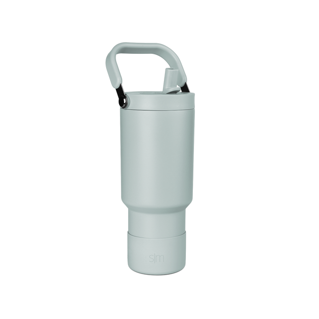 Pale sage green tote bag with black carabiner handles on sides