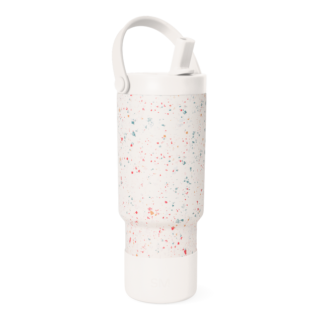 Cream-colored water bottle with multicolored speckled pattern including coral red, pink, teal, sage green, and muted orange accents.