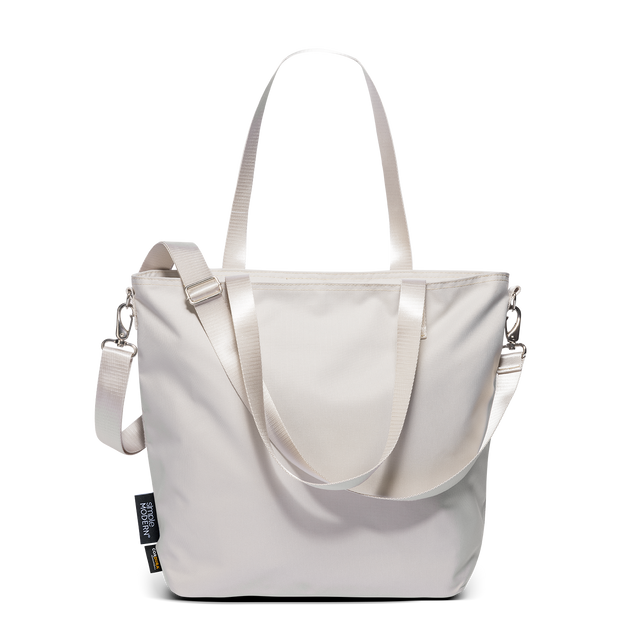 Harper Tote in cream Cordura fabric with dual webbing handles, adjustable crossbody strap, and silver-tone hardware on white background.