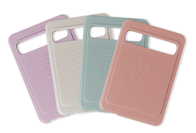 Four smartphone cases arranged in a fan display: dusty lavender purple, warm cream, soft sage green, and additional case in pastel tones.